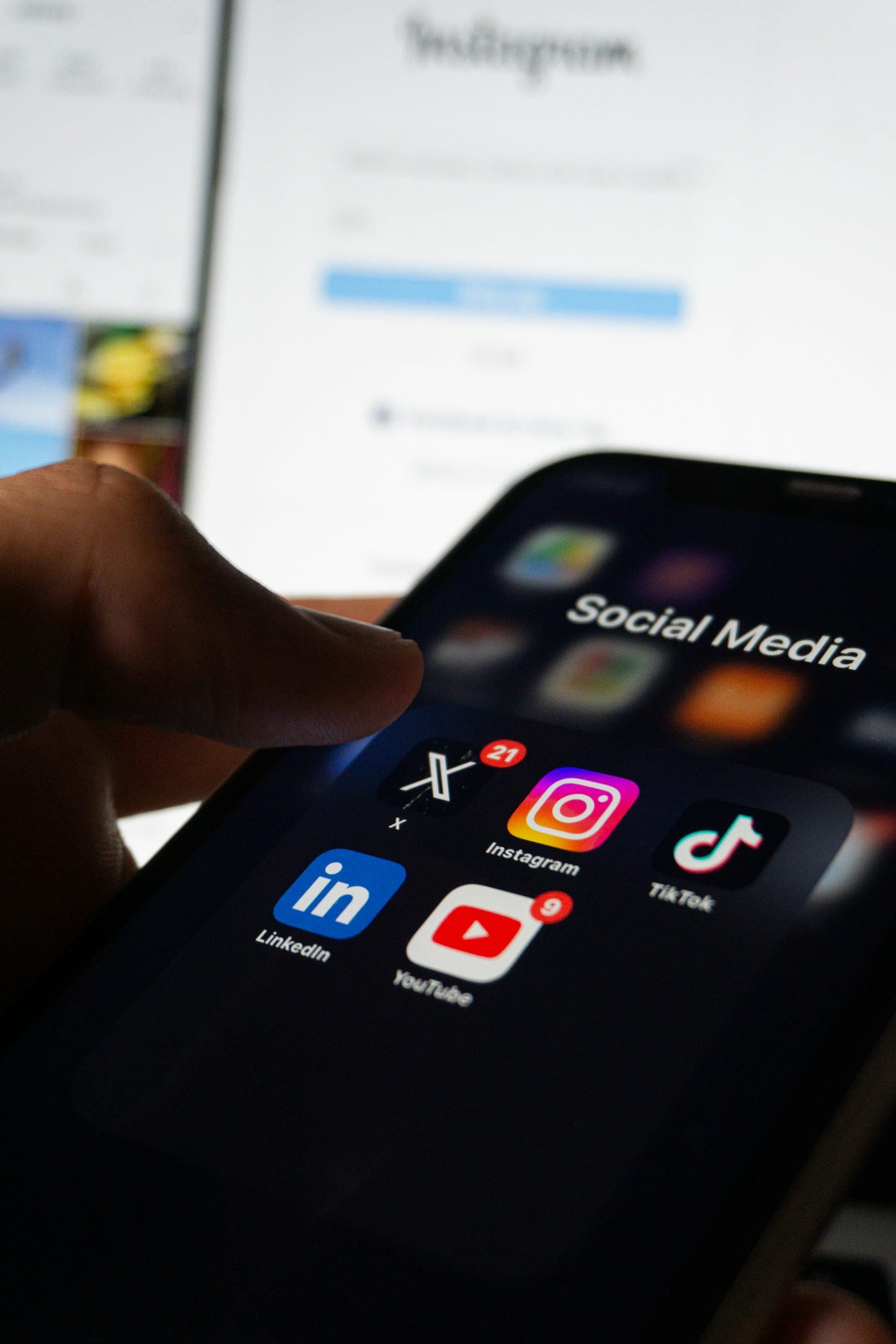 Mão segurando smartphone com aplicativos de redes sociais